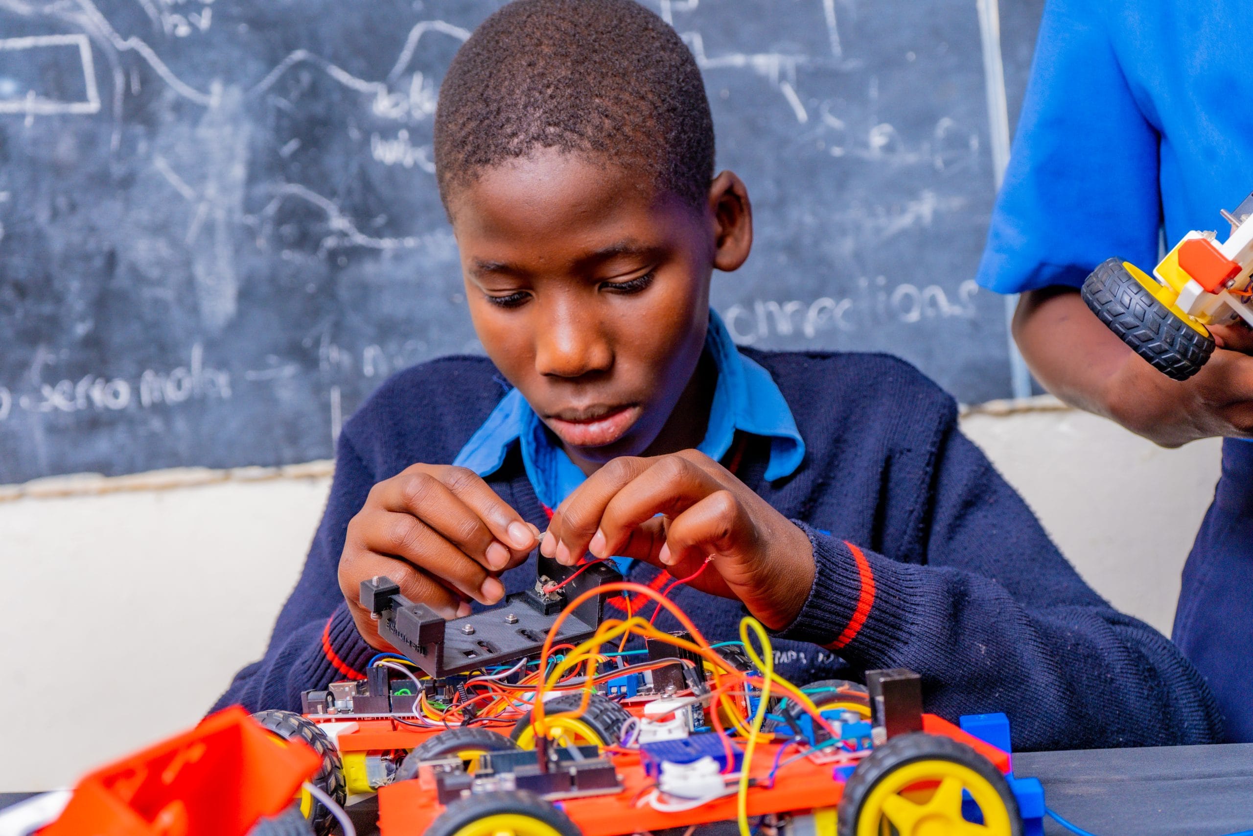 Karibu International School student assembling a robotics car in a STEM class